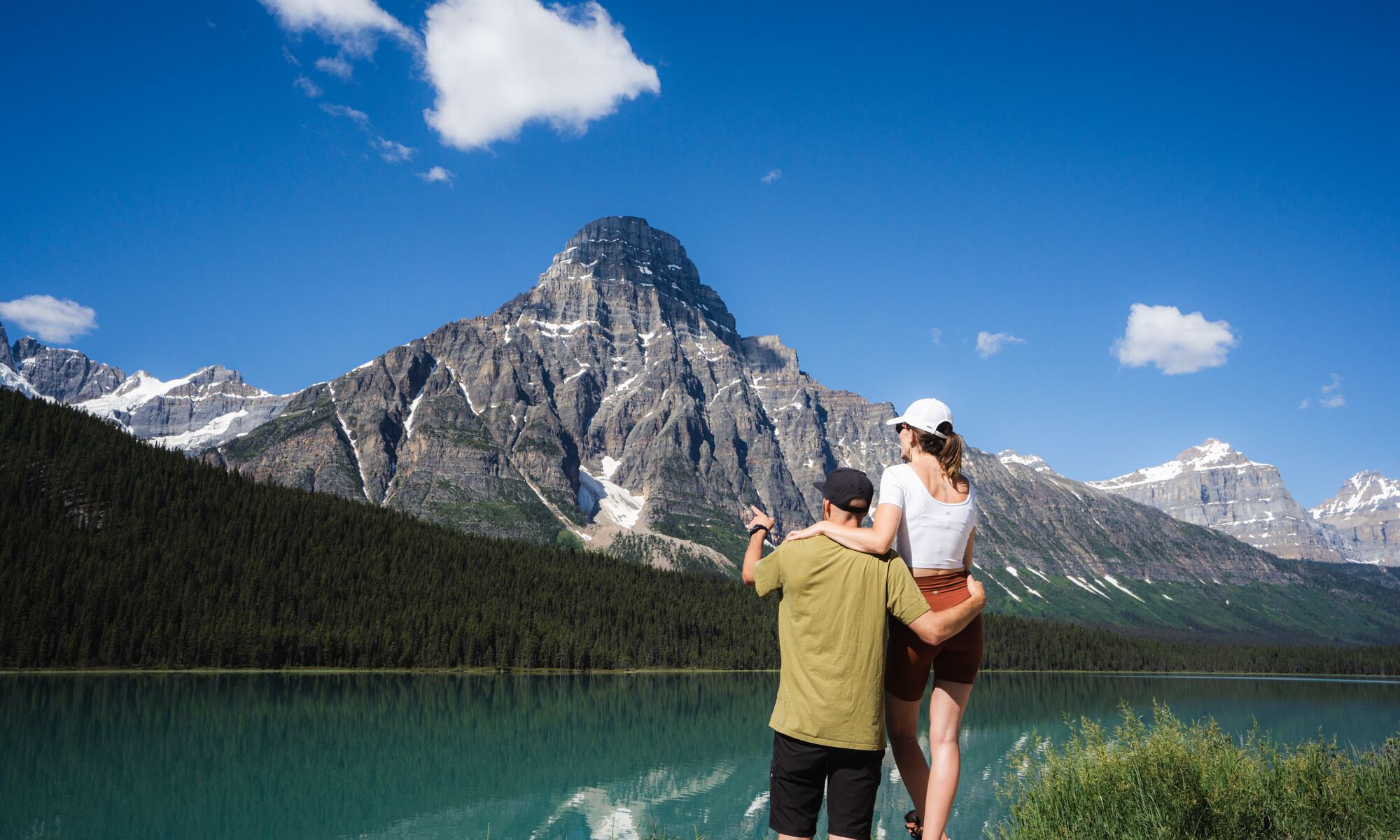 Two people look out at Waterfowl Lake in Banff National Park.